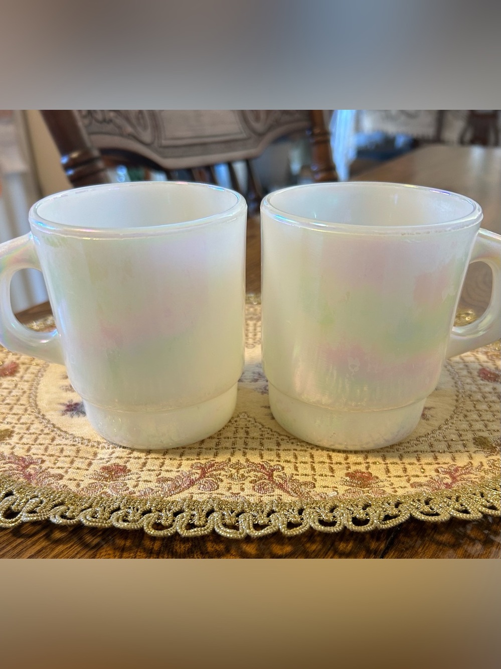 A pair of vintage Anchor Hocking Fire King white pearl iridescent stacking mugs.